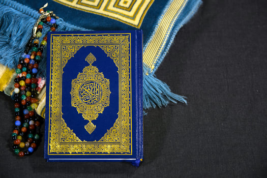 a blue and gold quran with a gold chain photo