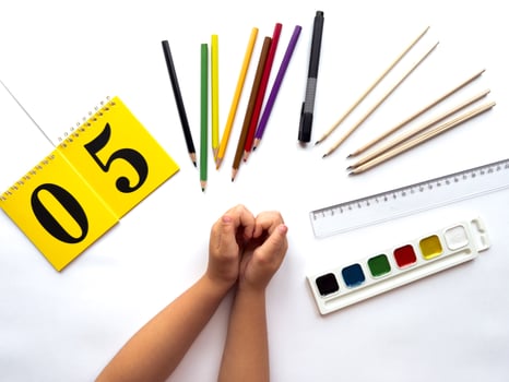 Creative workspace with art supplies and yellow calendar on white background photo