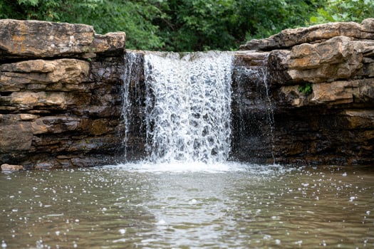 Tranquil waterfall in lush green forest photo