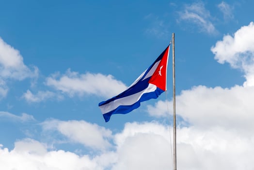 National flag of Cuba on a flagpole against a beautiful sky photo