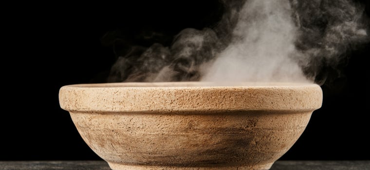 Steaming ceramic bowl on dark background photo