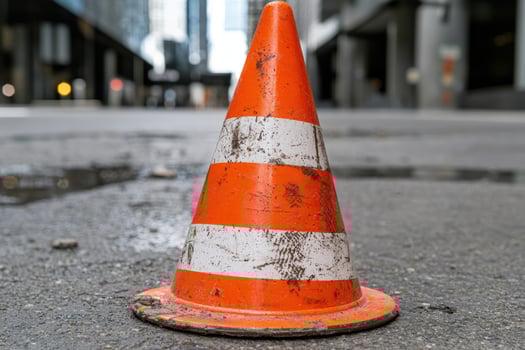 Bright orange traffic cone on city street photo