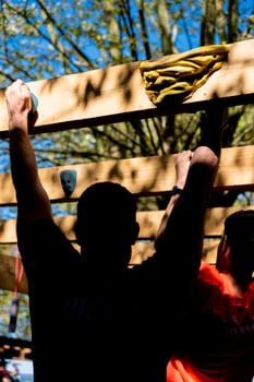 athletes participating in an ocr obstacle course race overcoming one of the tests photo