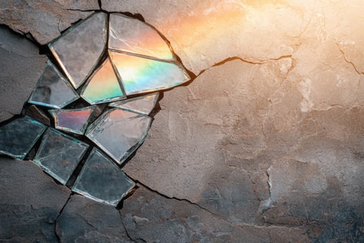 Shattered glass reflecting colorful light on textured stone background photo