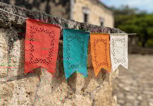 Colorful decorative flags hanging on a stone wall photo