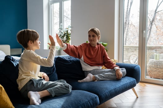 Older sister spending time with younger brother at home photo