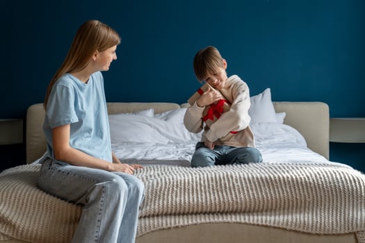 Loving young caucasian mother congratulating happy cute little boy son with wrapped birthday gift photo