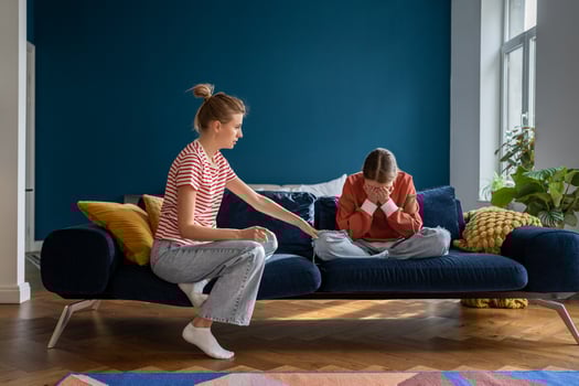 Loving supportive mother comforting upset crying teen daughter while sitting together on sofa photo