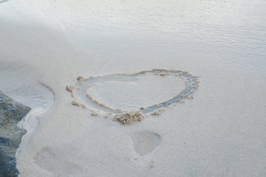 Heart drawn on the beach sand photo