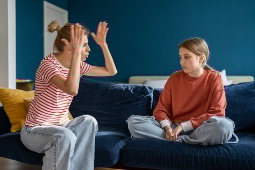 Young angry emotional mother screaming at troubled teen daughter at home photo