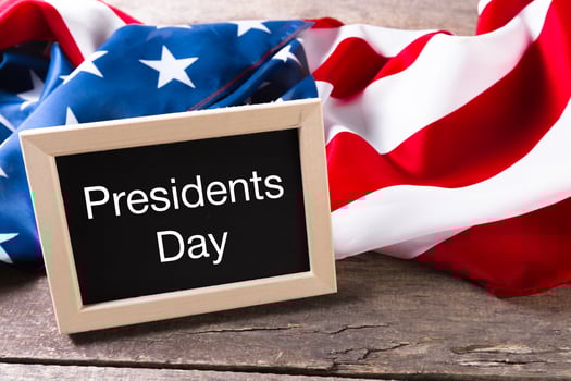 the text happy presidents day written in a chalkboard and a flag of the United States photo