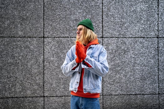 Pensive Scandinavian slim guy hipster with long blond hair, lgbt person waiting friend meeting photo