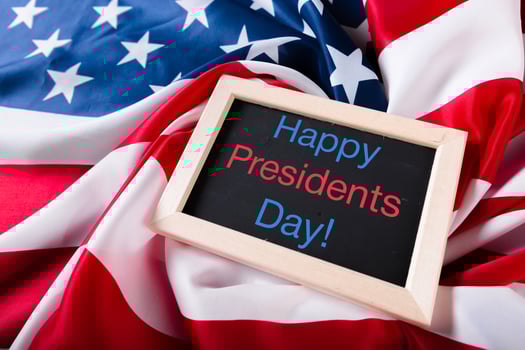 the text happy presidents day written in a chalkboard and a flag of the United States photo