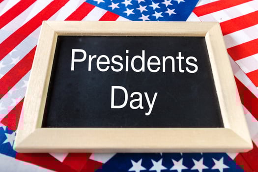 the text happy presidents day written in a chalkboard and a flag of the United States photo