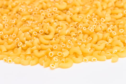 A Heap of Uncooked Chifferi Rigati Pasta on White Background. Fat and Unhealthy Food. Classic Dry Macaroni Texture. Italian Culture and Cuisine. Raw Pasta photo