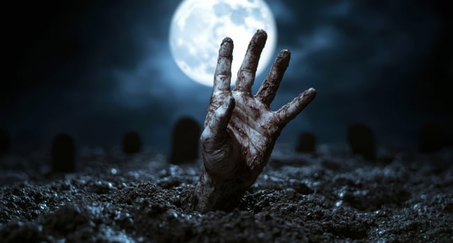 Spooky hand emerging from the ground under a full moon photo