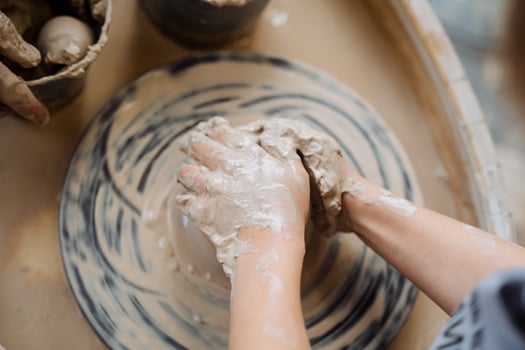A child's hands are making clay on a pottery wheel photo