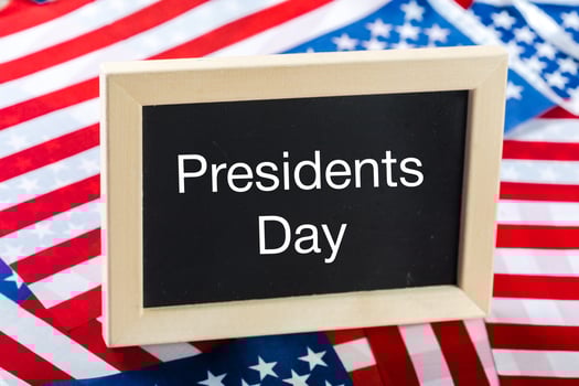 the text happy presidents day written in a chalkboard and a flag of the United States photo