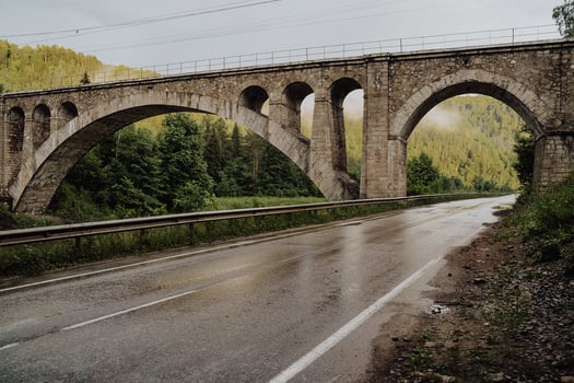 Stone railway bridge of the 19th century, old arch bridge over the river, the road passes under the railway bridge photo