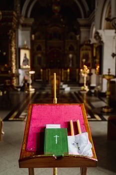 Church book the Bible is on the table in the temple, items for the wedding ceremony, candles, cross, close-up photo