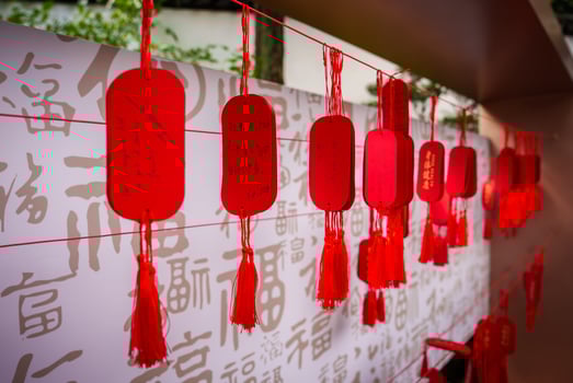Red Wish Tags with Tassels Against Chinese Character Wall in Shanghai photo
