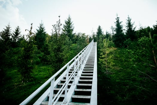 white staircase going up. stairs steps in the park descent from the mountain. landscaped area for walking. metal staircase. photo