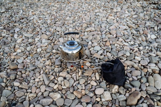 Cooking on a hike on the banks of the river. The concept of tourist cuisine. Tableware for tourists. Minimalism in travel. photo