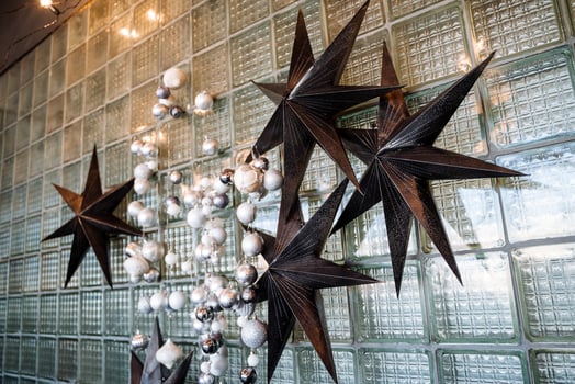 Large stars and a garland of Christmas balls hang on the wall. Decorations for the new year and Christmas. Festive mood in the house. photo