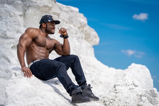 Young athletic macho on summer outside. Shirtless muscular bodybuilder outdoor standing. photo