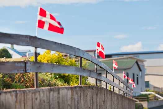 Danish flags in a row on a wooden fence in a village photo