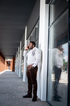 Handsome young man talking with phone outdoor. Business communication. photo
