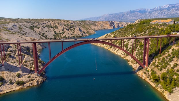 Bungee jumping activity from a bridge above the sea. Aerial view person attached to a rope on the bridge. Maslenica bridge, Croatia, travel destinations. photo