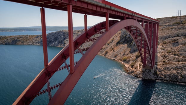 Engineering sector bridge construction. Infrastructure above the sea. Parts of the red steel arch bridge. Road viaduct Maslenica bridge, Croatia. photo