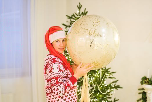 Girl in New Year Sweater and Hat Next to Christmas Tree photo