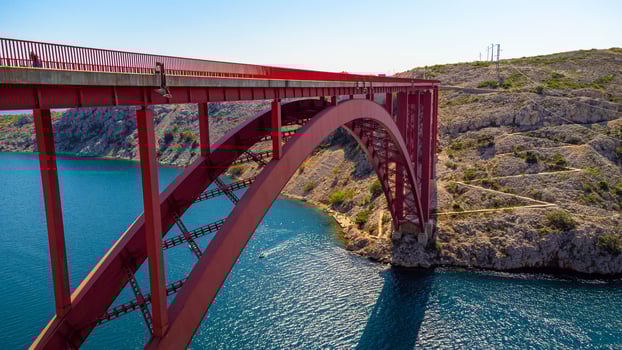 Engineering sector bridge construction. Infrastructure above the sea. Parts of the red steel arch bridge. Road viaduct Maslenica bridge, Croatia. photo
