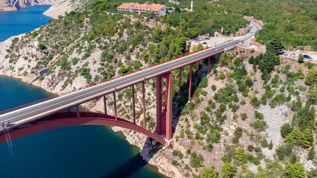 Engineering sector bridge construction. Infrastructure above the sea. Parts of the red steel arch bridge. Road viaduct Maslenica bridge, Croatia. photo