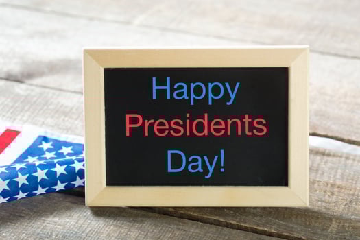 the text happy presidents day written in a chalkboard and a flag of the United States photo