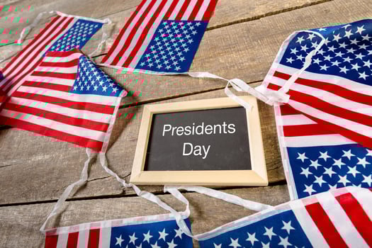 the text happy presidents day written in a chalkboard and a flag of the United States photo