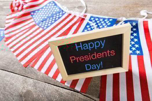 the text happy presidents day written in a chalkboard and a flag of the United States photo