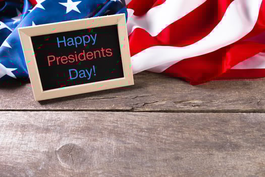 the text happy presidents day written in a chalkboard and a flag of the United States photo