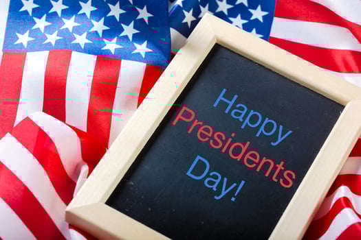 the text happy presidents day written in a chalkboard and a flag of the United States photo