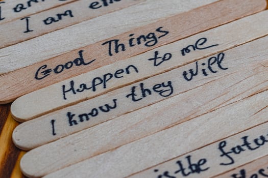 Positive thoughts for self esteem on wooden sticks on a wooden table photo