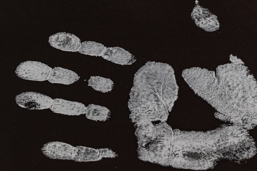 An angled view of a human male handprint on black cardboard photo