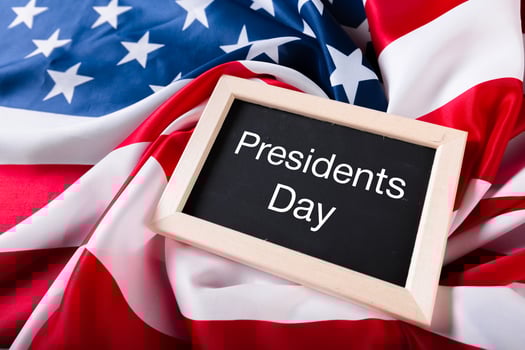 the text happy presidents day written in a chalkboard and a flag of the United States photo