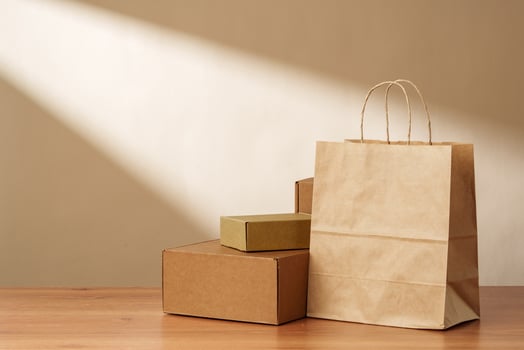Brown Paper Bag and Cardboard Boxes on a Wooden Surface photo