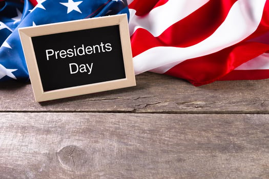 the text happy presidents day written in a chalkboard and a flag of the United States photo