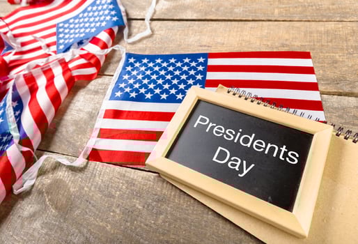 the text happy presidents day written in a chalkboard and a flag of the United States photo