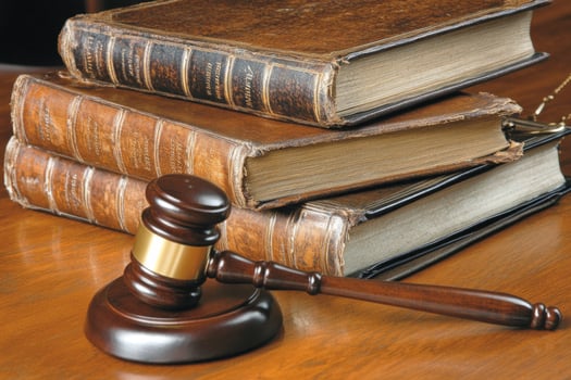 Judges gavel rests beside law books on a wooden desk in a professional atmosphere symbolizing justice photo