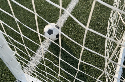 Soccer ball in goal on blue background photo