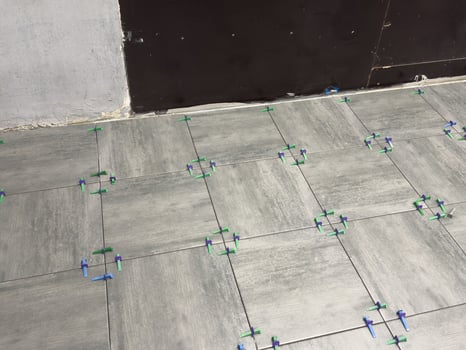 Laying Ceramic Tiles. Worker putting tiles on the balcony. photo